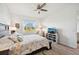 Bright main bedroom featuring a ceiling fan, a sitting area, and natural light from the backyard-facing windows at 2471 Kensington Greens Dr, Sun City Center, FL 33573