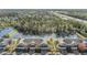 Scenic aerial view of townhomes near a pond and highway, showcasing the community layout at 26850 Juniper Bay Dr, Wesley Chapel, FL 33544