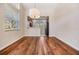 Sunlit dining area with wood floors, high ceilings, and a view into the adjoining kitchen space at 26850 Juniper Bay Dr, Wesley Chapel, FL 33544