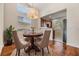 Bright dining area with high ceilings, view into kitchen, and a round table with seating for four at 26850 Juniper Bay Dr, Wesley Chapel, FL 33544