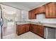 Well-lit kitchen featuring wood cabinets, stainless steel appliances, and an open layout to the living area at 26850 Juniper Bay Dr, Wesley Chapel, FL 33544