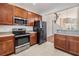 Cozy kitchen complete with stainless steel appliances, wood cabinetry, and ample counter space for meal preparation at 26850 Juniper Bay Dr, Wesley Chapel, FL 33544