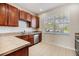 A bright kitchen showcasing wooden cabinets, stainless steel appliances, tile backsplash, and ample countertop space at 26850 Juniper Bay Dr, Wesley Chapel, FL 33544