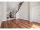 Open-concept living space with hardwood floors, staircase, and views into the adjacent kitchen area at 26850 Juniper Bay Dr, Wesley Chapel, FL 33544