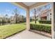 Covered patio overlooking a serene pond with lush green grass and mature trees at 26850 Juniper Bay Dr, Wesley Chapel, FL 33544