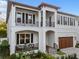 Elegant two-story home with a white exterior, detailed iron balconies, a 2-car garage, and manicured landscaping at 2810 W Alline Ave, Tampa, FL 33611