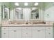 Bright bathroom featuring a double vanity, granite countertops, and dual mirrors at 301 Mariner Dr # 301, Tarpon Springs, FL 34689