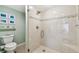 Updated bathroom featuring a glass shower with tiled walls, a shower seat and modern fixtures at 301 Mariner Dr # 301, Tarpon Springs, FL 34689