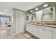 Well-lit bathroom boasting a double vanity with granite counters and a view to the bedroom at 301 Mariner Dr # 301, Tarpon Springs, FL 34689