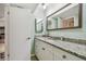 Bathroom featuring a granite countertop, white cabinets, a large mirror, and modern fixtures at 301 Mariner Dr # 301, Tarpon Springs, FL 34689