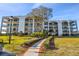 Beautiful condo building featuring well-manicured landscaping, red brick accents, and inviting curb appeal at 301 Mariner Dr # 301, Tarpon Springs, FL 34689