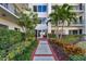 Exterior entrance showcasing lush landscaping and a well-maintained building facade at 301 Mariner Dr # 301, Tarpon Springs, FL 34689