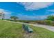 Relaxing exterior view of a bench along a walking path with a view of the water in the distance at 301 Mariner Dr # 301, Tarpon Springs, FL 34689