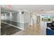 Hallway featuring tiled floors, gray walls, seating, and a glimpse of the serene ocean at 301 Mariner Dr # 301, Tarpon Springs, FL 34689