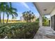 Peaceful condo patio with lush tropical landscaping and a view of a white building at 301 Mariner Dr # 301, Tarpon Springs, FL 34689