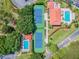 Aerial view of the community, with tennis courts and swimming pools surrounded by mature trees and lawns at 301 Mariner Dr # 301, Tarpon Springs, FL 34689