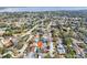 Neighborhood aerial view with lake and home featuring screened pool, fenced yard, and landscaping at 3116 Swan Ln, Safety Harbor, FL 34695