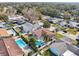 Beautiful aerial view of home featuring screened pool, lush landscaping, and neighborhood setting at 3116 Swan Ln, Safety Harbor, FL 34695