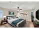 Staged main bedroom with a plush bed, stylish lamps, and wood flooring at 3116 Swan Ln, Safety Harbor, FL 34695