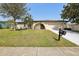 Charming single-story home featuring a well-manicured lawn and inviting arched entryway at 3116 Swan Ln, Safety Harbor, FL 34695