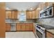 Well-lit kitchen with stainless steel appliances, tile backsplash, and granite countertops at 3116 Swan Ln, Safety Harbor, FL 34695