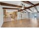 Open-concept living space featuring wood floors, exposed beams, and an adjacent kitchen at 3116 Swan Ln, Safety Harbor, FL 34695