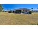 Exterior view of a house with a screened lanai, well-kept lawn, and landscaping at 315 Linger Ln, Sun City Center, FL 33573