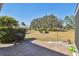 Paver patio leads to a well-maintained lawn with mature trees, bushes, and a grill, perfect for outdoor entertaining at 315 Linger Ln, Sun City Center, FL 33573