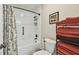 Tidy bathroom featuring white tiling, a shower and bathtub, and neatly stacked towels on shelving at 315 Linger Ln, Sun City Center, FL 33573