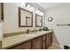 Bathroom featuring a granite countertop, modern sinks, wooden cabinets, and a large mirror at 315 Linger Ln, Sun City Center, FL 33573