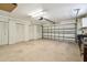 Spacious garage with multiple storage closets and an automatic door, providing ample space for parking and storage at 315 Linger Ln, Sun City Center, FL 33573