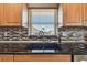 Close-up of kitchen sink area features a black granite countertop and mosaic backsplash at 315 Linger Ln, Sun City Center, FL 33573