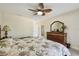 Well-lit bedroom showing a woven headboard, a ceiling fan, and hardwood furniture with a view to the ensuite at 315 Linger Ln, Sun City Center, FL 33573