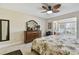 Bright bedroom featuring neutral walls, hardwood furniture, a sitting area, and a ceiling fan at 315 Linger Ln, Sun City Center, FL 33573