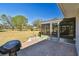 Paver patio with a grill, leading to a screened-in porch, and a view of the expansive yard at 315 Linger Ln, Sun City Center, FL 33573