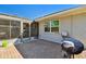 Paver patio leading to a screened-in area, including a grill, and a view of the yard and exterior of the home at 315 Linger Ln, Sun City Center, FL 33573