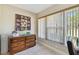 Small sitting room with a wooden dresser and a view of the outside through vertical blinds at 315 Linger Ln, Sun City Center, FL 33573