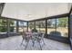 Enclosed sunroom with tile flooring, large windows, and a table and chairs, creating a cozy dining or relaxation space at 315 Linger Ln, Sun City Center, FL 33573