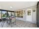 Enclosed sunroom with tile flooring, table, chairs, and a white door, offering a comfortable indoor-outdoor transition space at 315 Linger Ln, Sun City Center, FL 33573