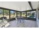 Enclosed sunroom featuring tile flooring and large windows showcasing the outdoor view, furnished with a table and chairs at 315 Linger Ln, Sun City Center, FL 33573