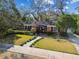 Charming brick home featuring mature landscaping, lush lawn, and a welcoming walkway to the front door at 4532 W Beachway Dr, Tampa, FL 33609