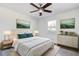 Bedroom view filled with natural light, modern artwork, side tables, and light colored wood flooring at 4570 69Th N Ave, Pinellas Park, FL 33781