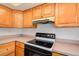 Kitchen with flat top stove and wood cabinets at 4570 69Th N Ave, Pinellas Park, FL 33781