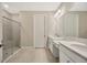 Elegant bathroom featuring double sinks, quartz countertops, and a glass-enclosed shower at 4576 Garofalo Rd, Wesley Chapel, FL 33543