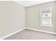 Bright bedroom with neutral carpet, a large window offering natural light, and painted walls at 4576 Garofalo Rd, Wesley Chapel, FL 33543