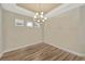 Dining room featuring hardwood floors and a modern chandelier at 4576 Garofalo Rd, Wesley Chapel, FL 33543