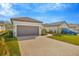 Home exterior featuring a two-car garage, paver driveway, lush lawn, and well-maintained landscaping at 4576 Garofalo Rd, Wesley Chapel, FL 33543