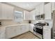 Modern kitchen with white cabinets, stainless steel oven, microwave, and light wood-style flooring at 4576 Garofalo Rd, Wesley Chapel, FL 33543