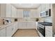 Bright kitchen featuring white cabinets, stainless steel appliances, and light wood-style flooring at 4576 Garofalo Rd, Wesley Chapel, FL 33543