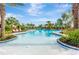 A luxurious swimming pool surrounded by palm trees, lounge chairs, and lush landscaping offers a resort-style experience at 4576 Garofalo Rd, Wesley Chapel, FL 33543